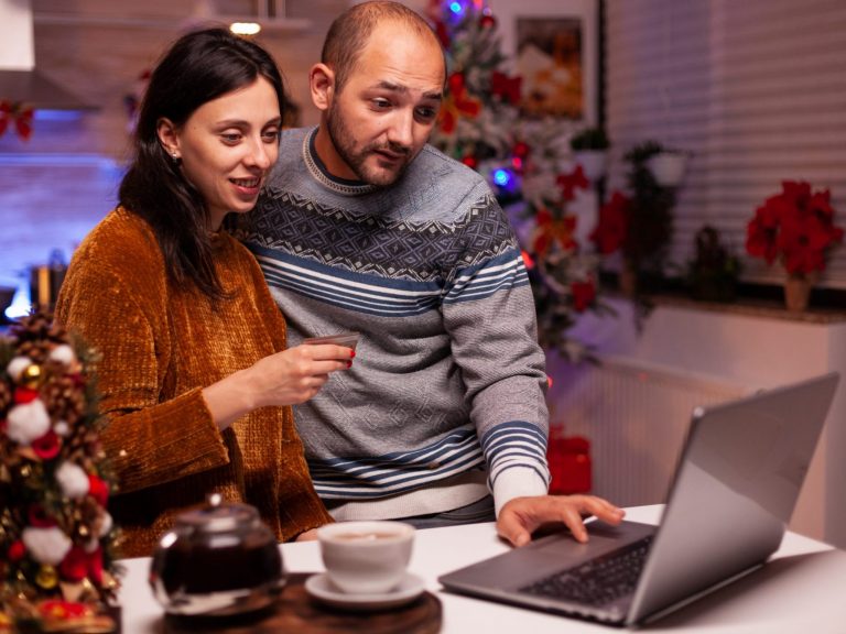 Photo of man and woman in front of laptop illustrates blog: 'Beware of Tax Scams This Holiday Season"