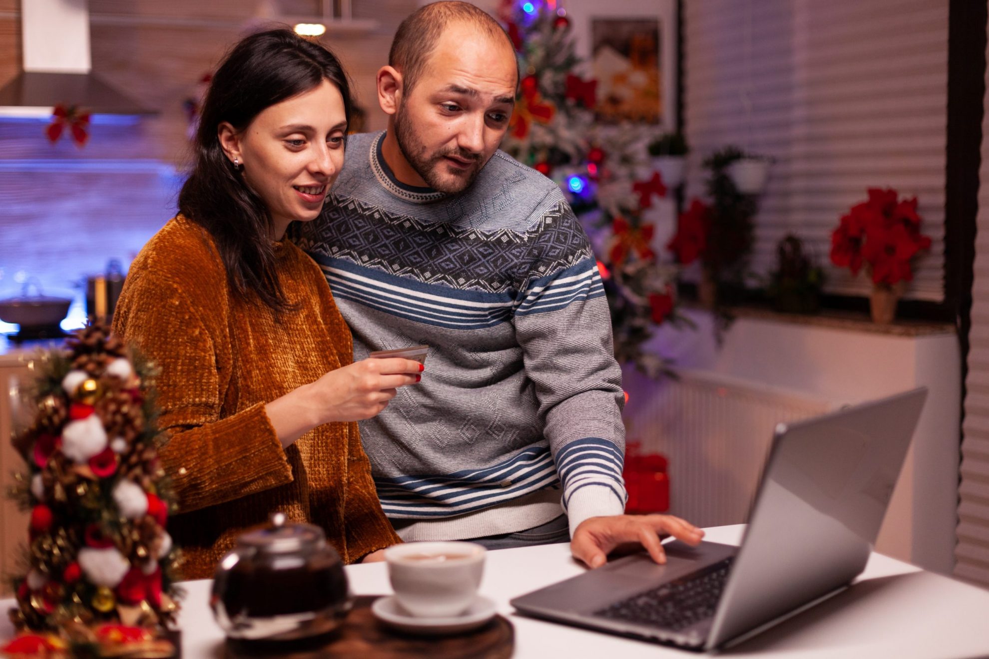 Photo of man and woman in front of laptop illustrates blog: 'Beware of Tax Scams This Holiday Season"