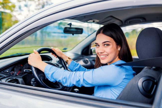 Photo of woman in car illustrates blog: "Like most states, California requires drivers to carry auto insurance. So this is an essential coverage if you live or plan to move to the Golden State. Keep reading to learn more about auto insurance in California, including some facts you probably didn’t know. "