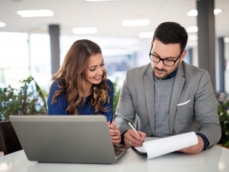 Photo of woman and man looking at paperwork illustrates blog: "Is It a Good Idea to Increase my Insurance Deductible to Save Money?"