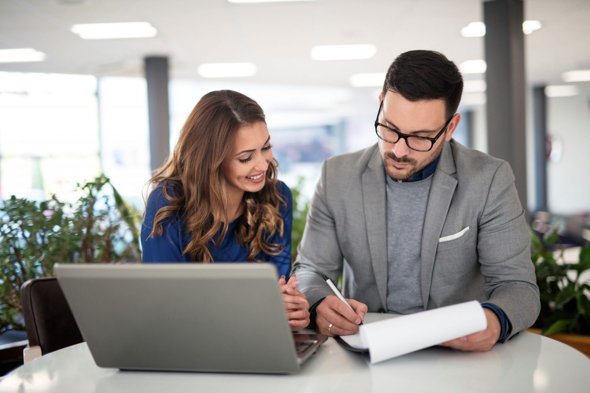 Photo of woman and man looking at paperwork illustrates blog: "Is It a Good Idea to Increase my Insurance Deductible to Save Money?"