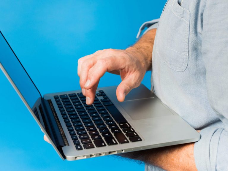 Photo of man with laptop illustrates blog: "How to Check the Status of a Refund"