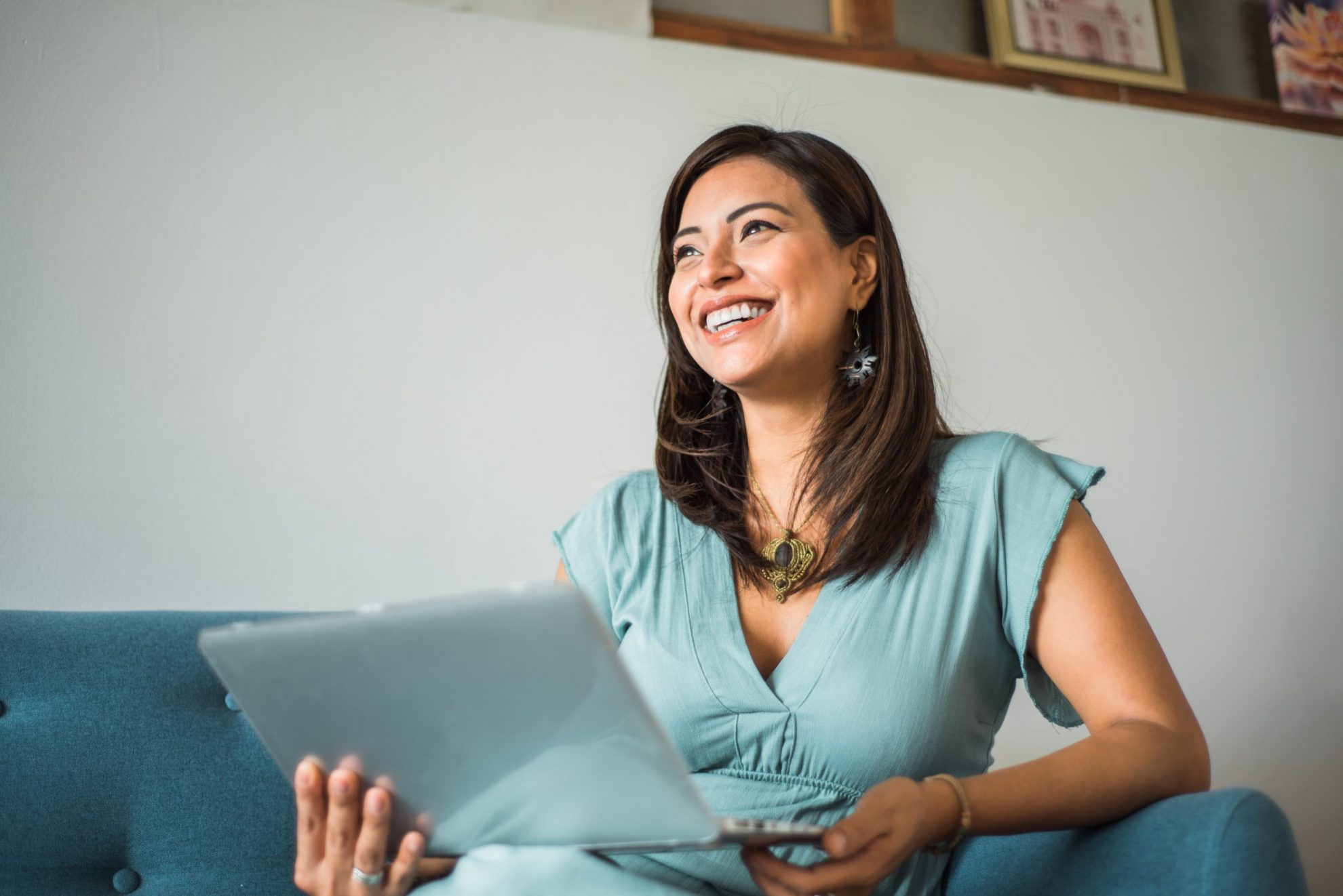 Photo of woman smiling with laptop illustrates blog: "Quick Tips for Tax Day"