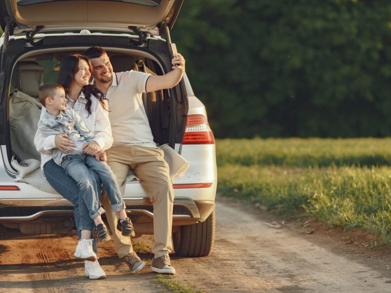Photo of family posing for selfie in the back of a SUV illustrates blog: "Full Coverage Auto Insurance in California: What You Need to Know"