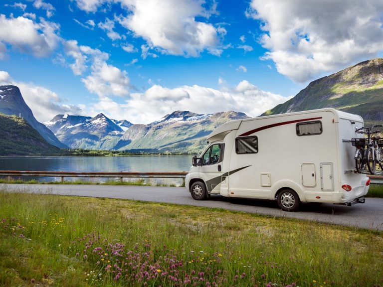 Photo of RV in front of lake and mountains illustrates blog: "Is RV Insurance Required in California?"