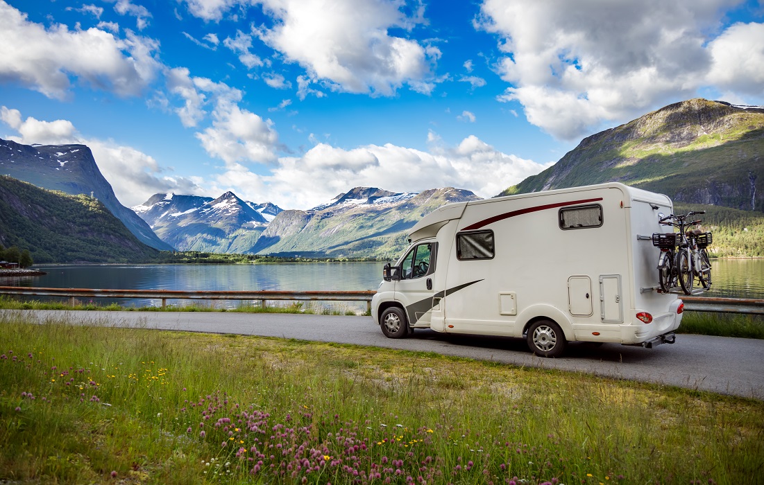 Photo of RV in front of lake and mountains illustrates blog: "Is RV Insurance Required in California?"