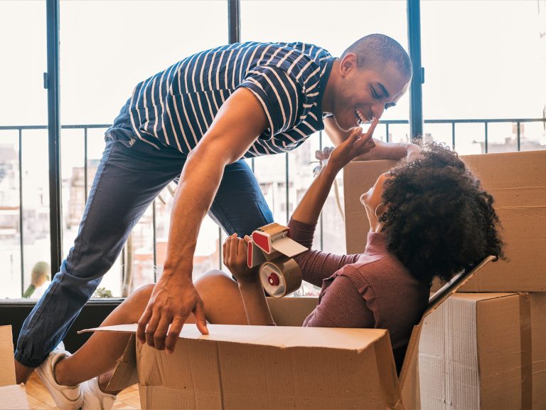 Photo of couple in new home with cardboard boxes illustrates blog: "California Renters Insurance Laws: What You Need to Know"