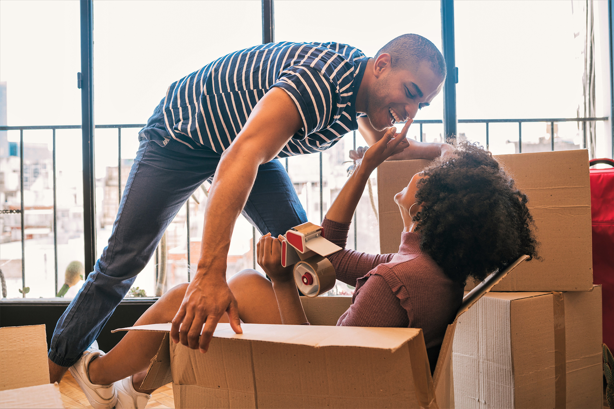 Photo of couple in new home with cardboard boxes illustrates blog: "California Renters Insurance Laws: What You Need to Know"