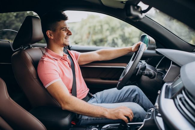 Photo of man driving car illustrates blog: "Does Your Credit Score Impact Your Auto Insurance Rates?"