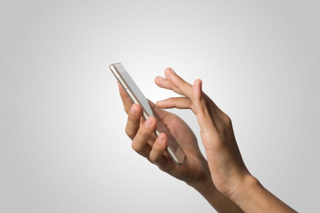 Photo of hands holding smartphone illustrates blog: "Beware of the Two Most Common Types of Holiday Scams"