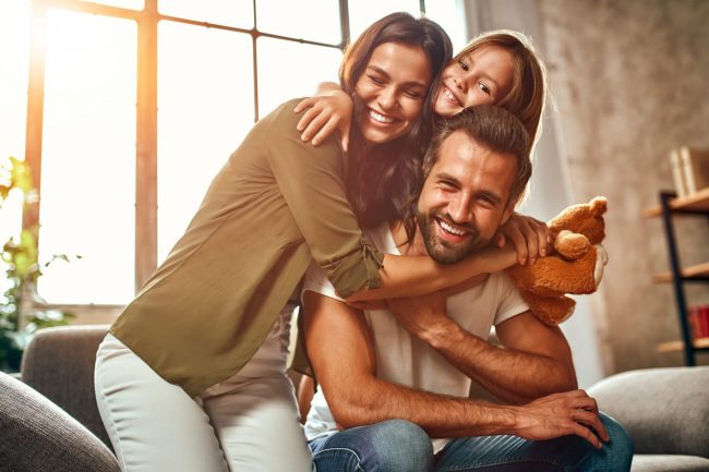 Photo of happy family illustrates blog "7 Factors That Impact Your Home Insurance Rates"