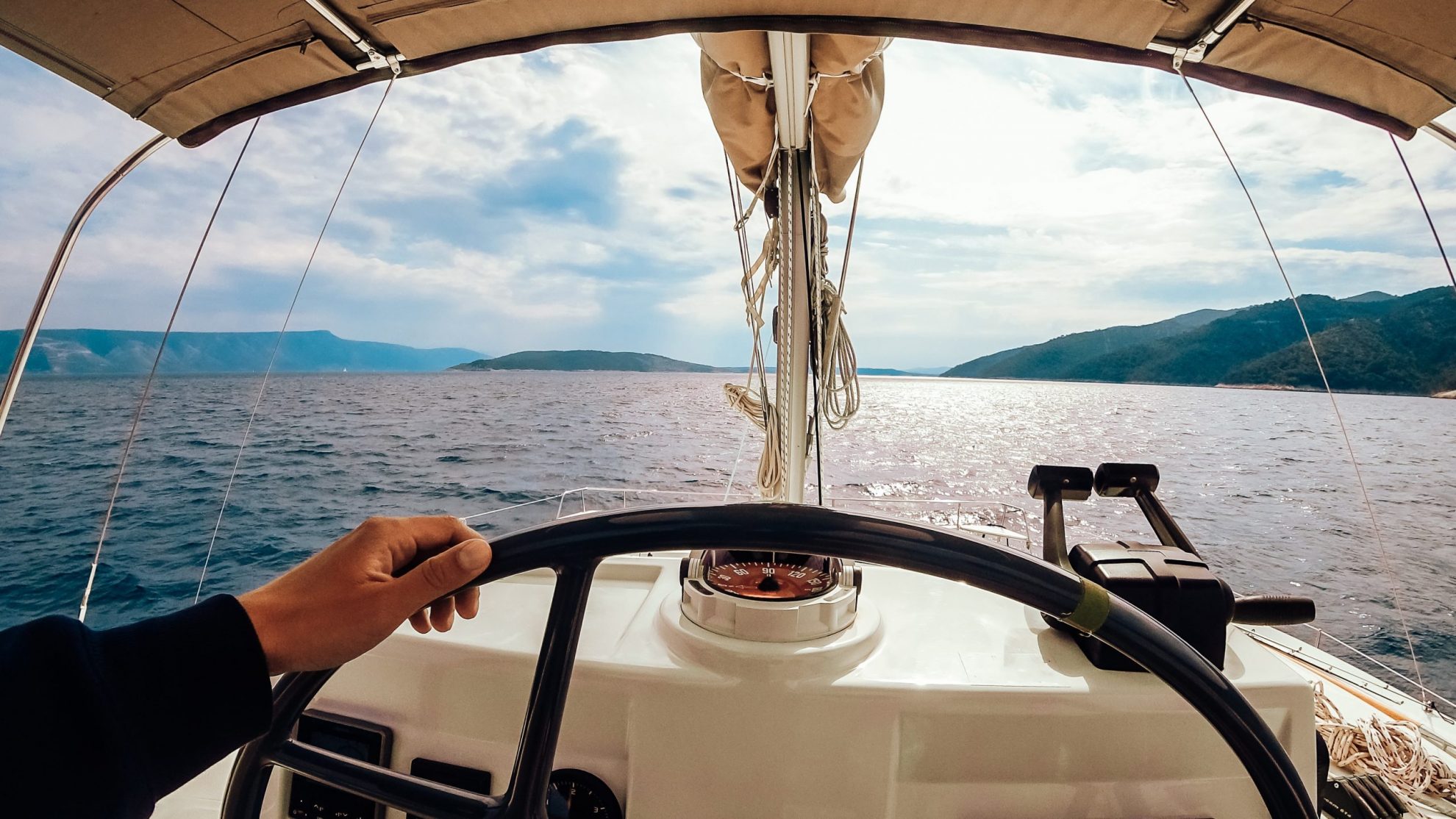 First-person view of man driving boat illustrates blog: "Do You Need Boat Insurance During the Winter Months?"
