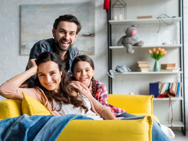 Photo of family in living room illustrates blog: "Is Home Insurance Mandatory When You Take Out a Home Loan?"