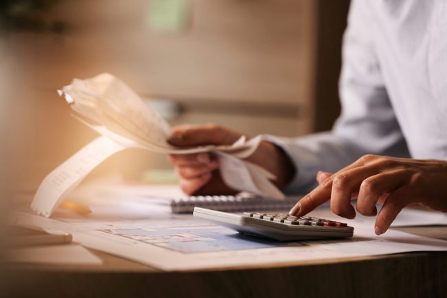 Close-up of person using calculator illustrates blog "California Extends Tax Deadline for California Storm Victims"