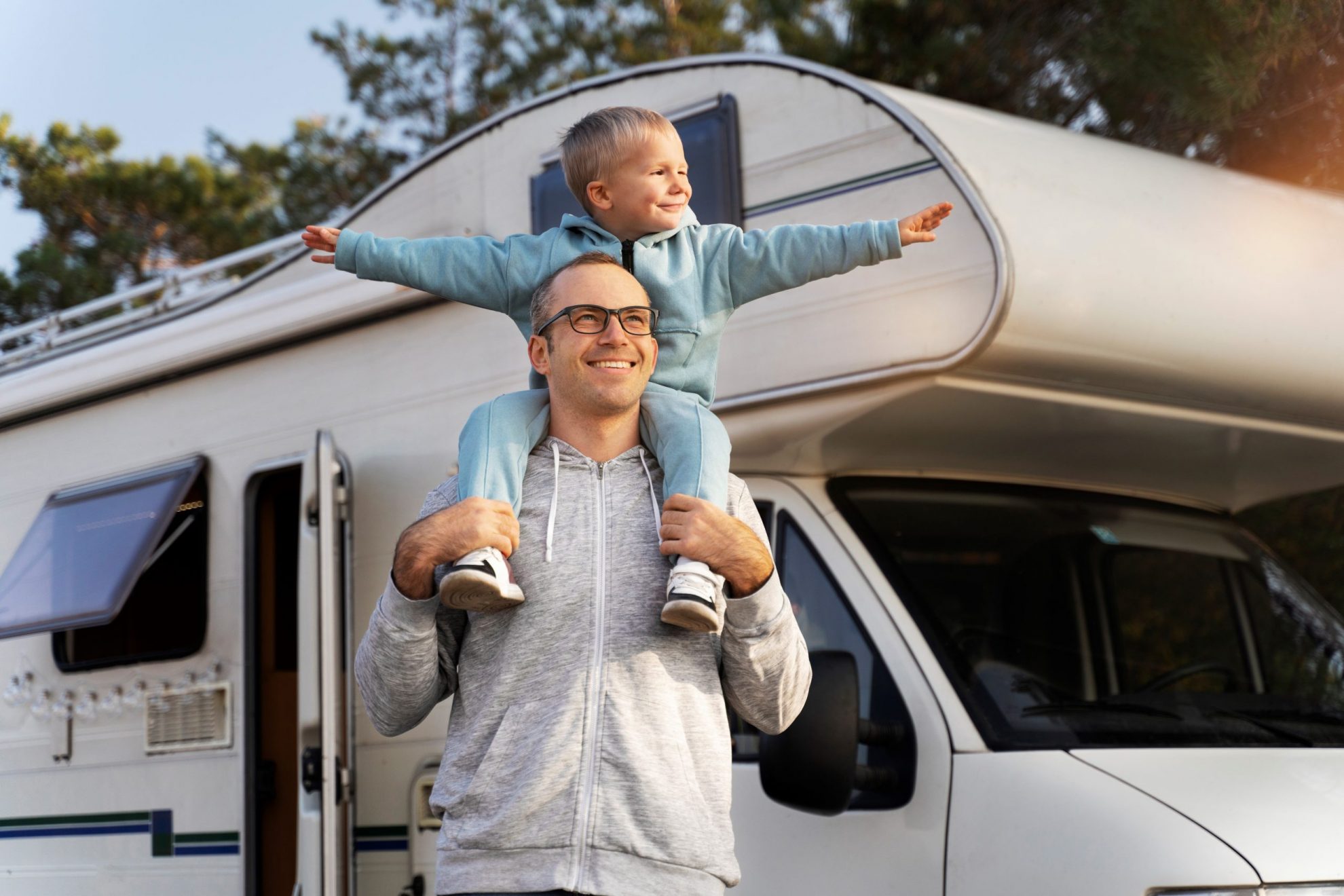 RVInsurance3 Man carrying child on his shoulders with RV in the background