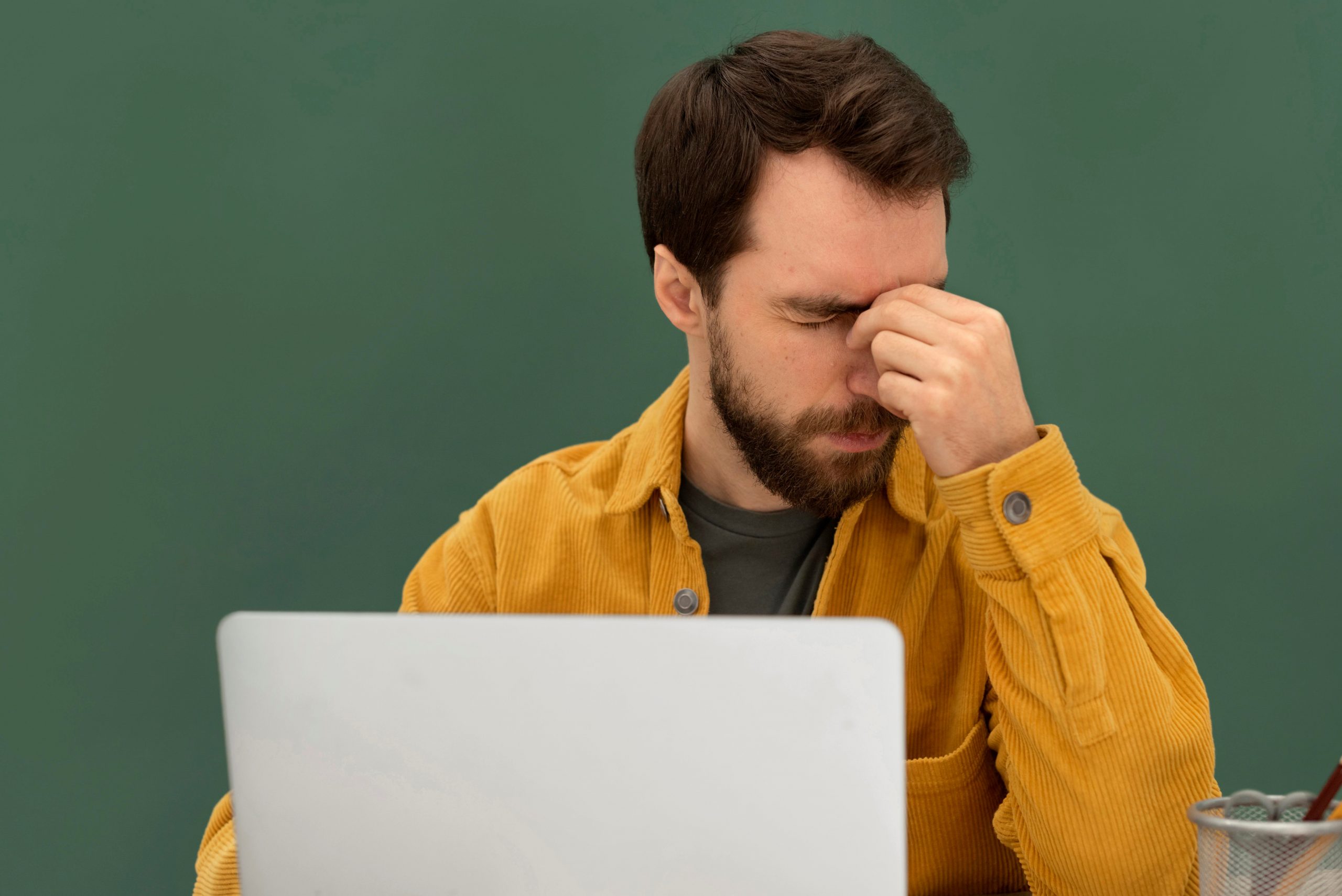 Scam2 Stressed man in front of laptop illustrates blog "Don’t Fall for This Tax-Related Online Scam!"
