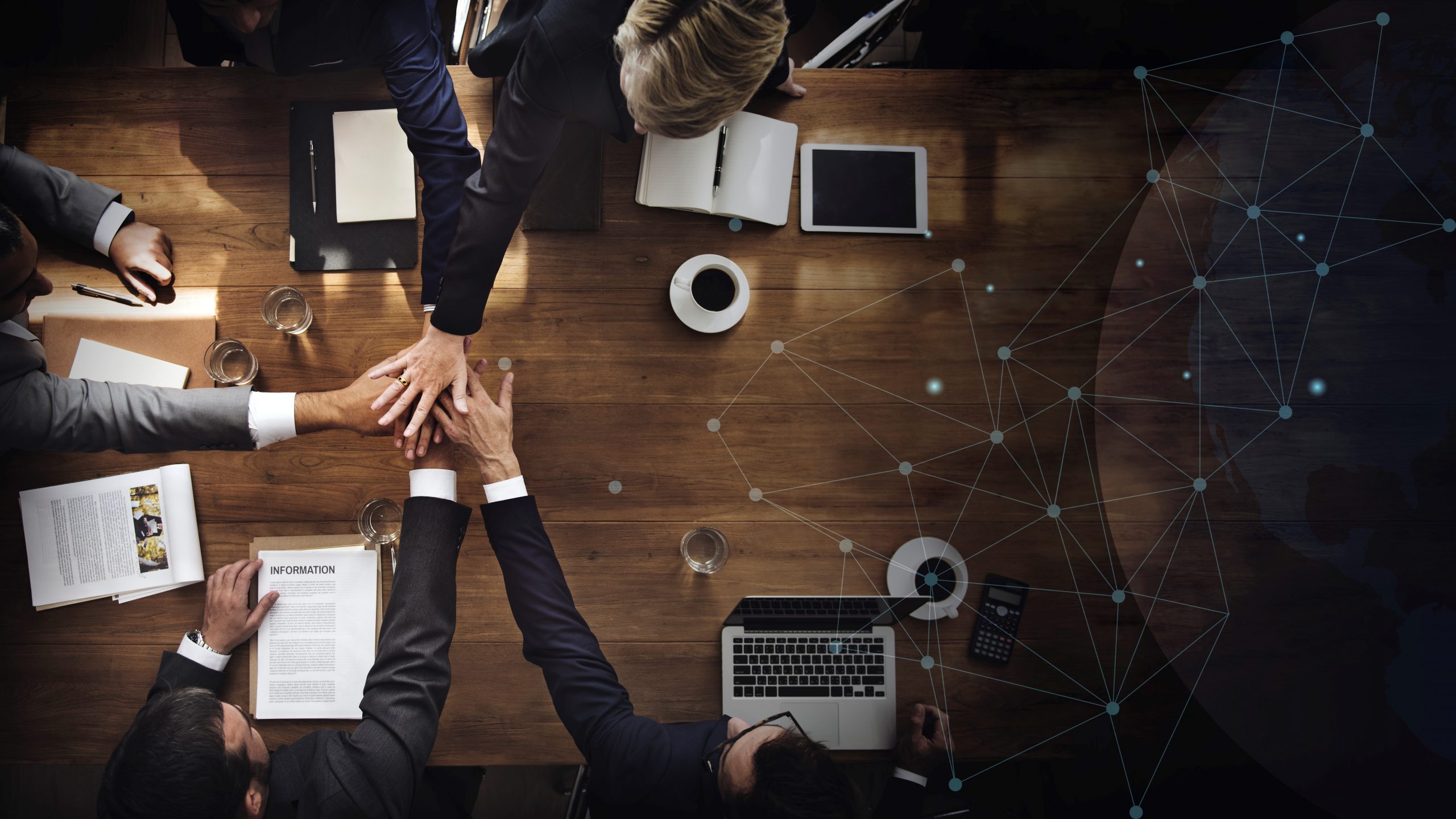 Aerial view of a business team People in business attire putting hands together illustrate blog "What Is a C Corporation? "