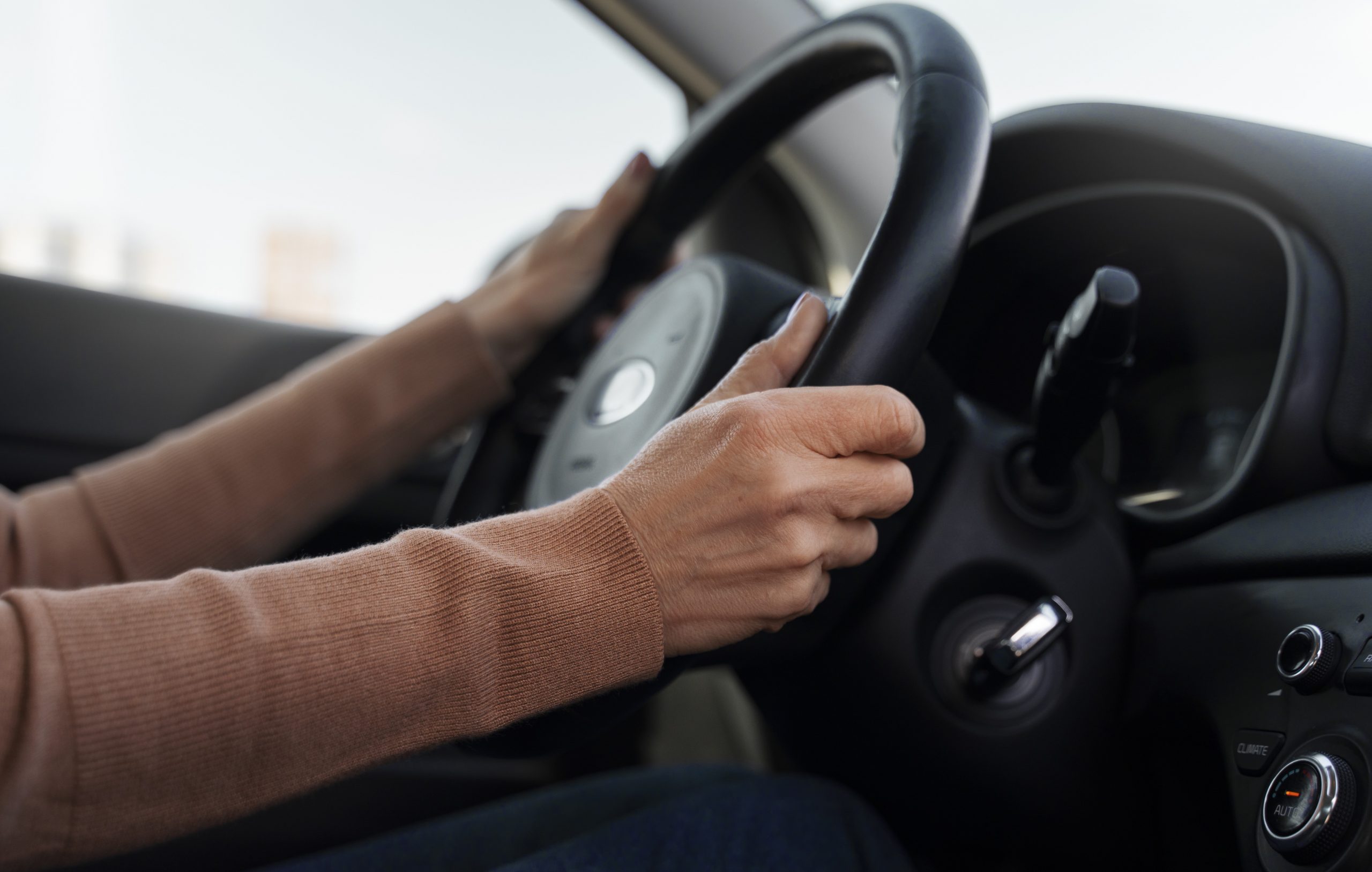 drive-fp Closeup of woman holding steering wheel illustrates blog "Does Auto Insurance Cover Theft?"