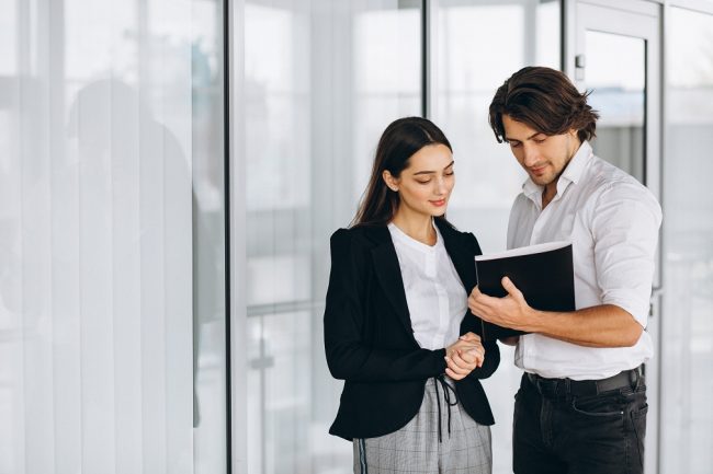 Two collegues working in a business center Businesspeople illustrate blog "10 Business Insurance Terms You Need to Know"