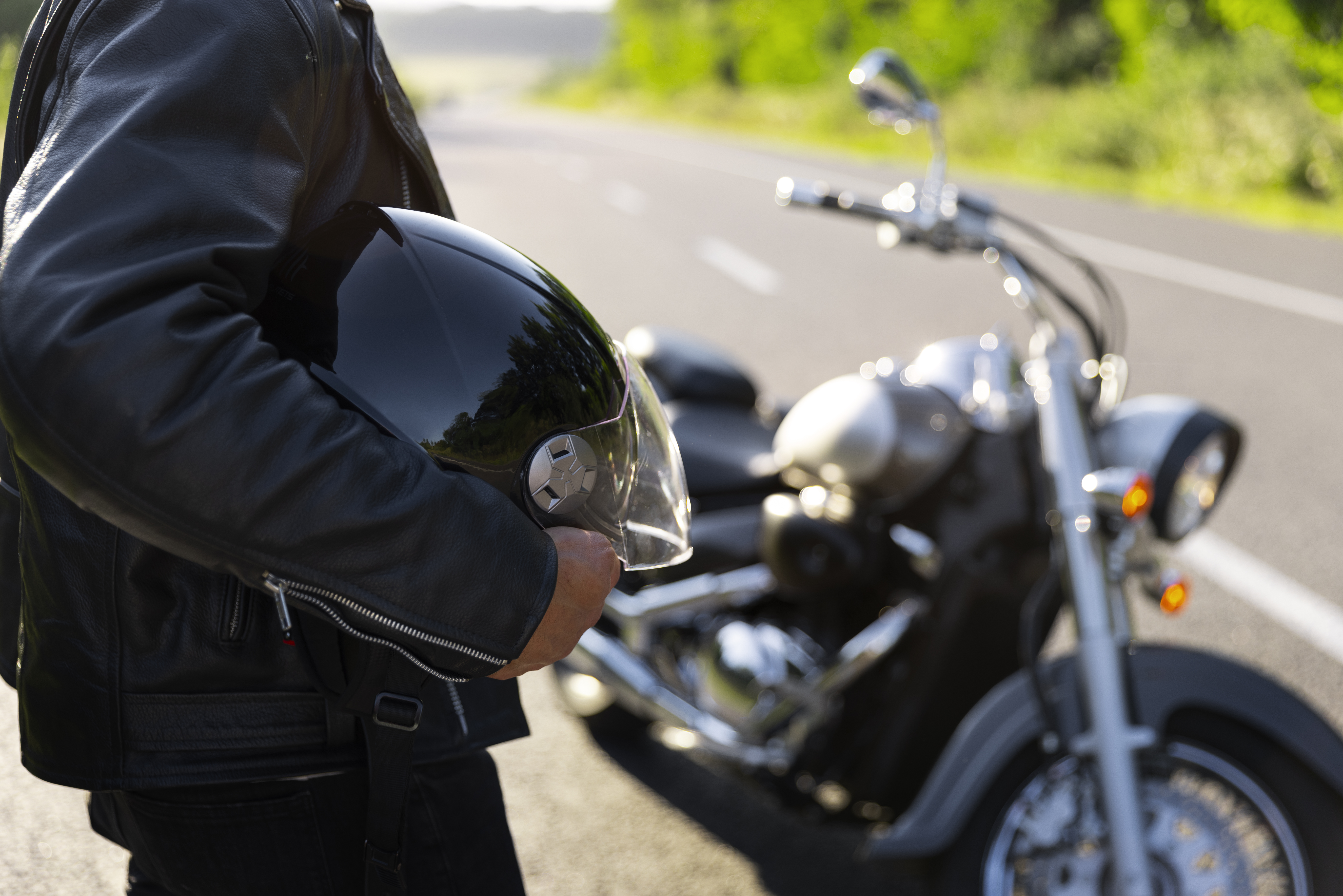 side-view-man-with-motorbike Motorcyclist reviewing insurance coverage options in California