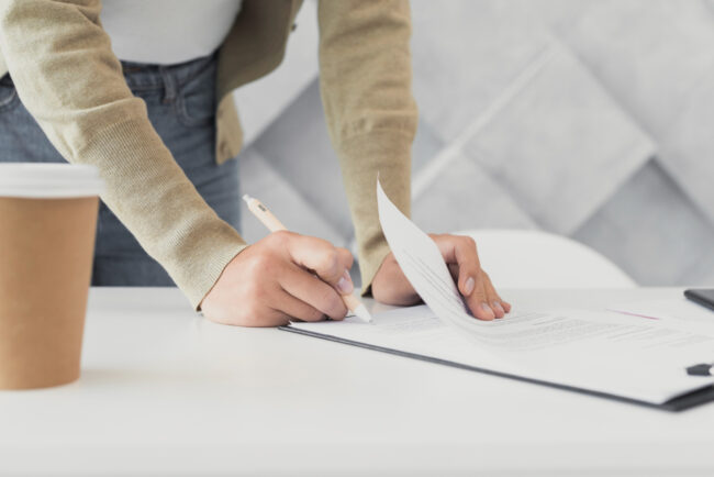 woman-signing-paper-close-up Steps to file a home burglary insurance claim in California
