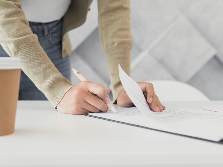 woman-signing-paper-close-up Steps to file a home burglary insurance claim in California