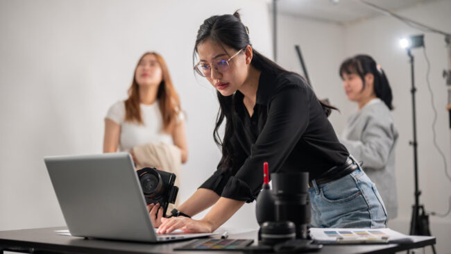 confident-female-photographer-checking-images-her-laptop-working-with-her-team-studio Microinsurance for gig workers in California