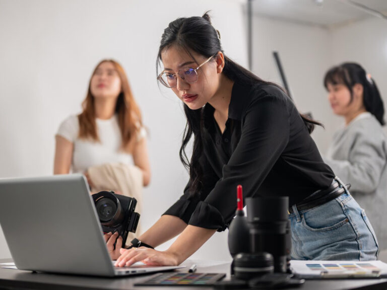confident-female-photographer-checking-images-her-laptop-working-with-her-team-studio Microinsurance for gig workers in California